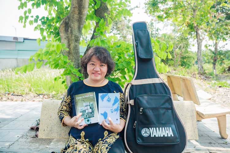 Human Rights Watch - Pham Doan Trang with two books that she co-authored, 2019. © Private